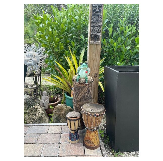 Yard art, bongo drums and a carved totem at Hawks' Point garden in Verandah