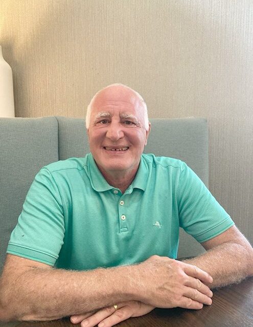 Resident Michael Pinto seated in a teal polo shirt