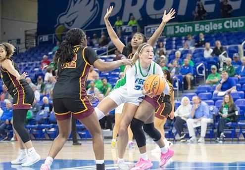 FGCU womens basketball player driving past two defenders during a home game